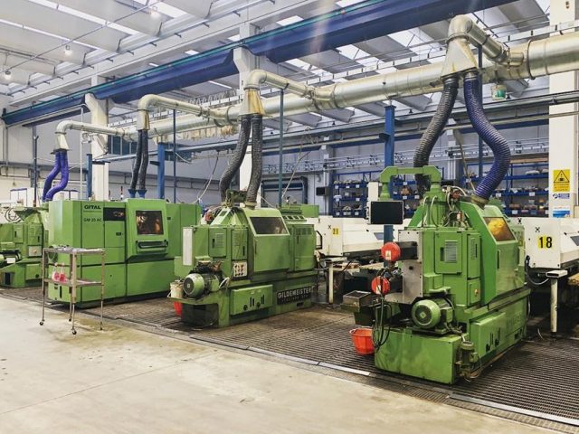 In questa foto si vedono dei macchinari grandi di colore verde visti di lato per le minuterie meccaniche Bergamo